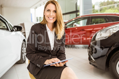 Smiling saleswoman writing on a clipboard