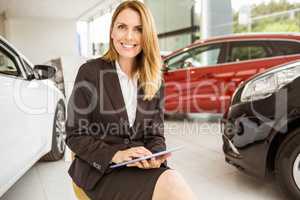 Smiling saleswoman writing on a clipboard