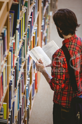 Student picking a book from shelf in library