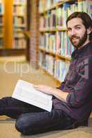 Student reading book in library on floor