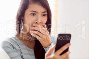 Asian woman reading shocking text