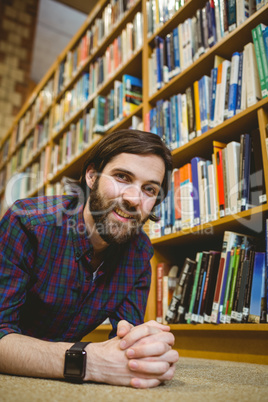 Student smiling on floor in library wearing smart watch