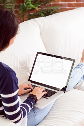 Asian woman on the couch using laptop