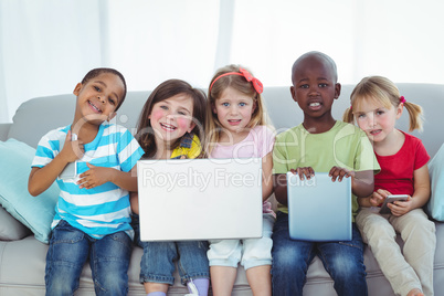 Happy kids using technology while sitting