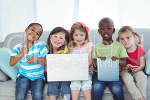 Happy kids using technology while sitting