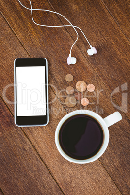 View of a white smartphone with a cup of coffee