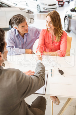 Smiling couple buying a new car