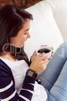 Asian woman relaxing on couch with coffee