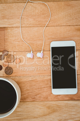 Coffee and white smartphone with white headphones