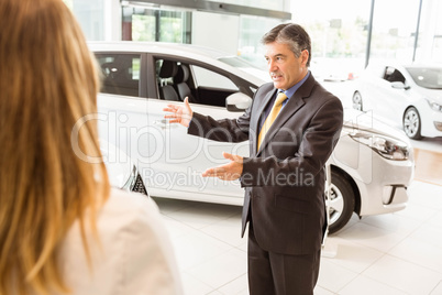 Salesman showing a car to a client