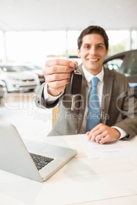 Smiling salesman holding a customer car key