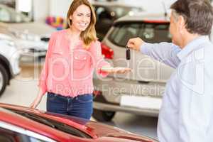 Smiling businessman giving car key to happy customer