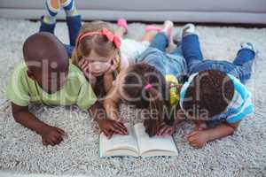 Happy kids reading a book together