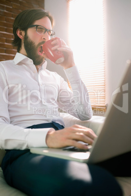 Businessman using laptop on the couch Businessman using laptop on the couch
