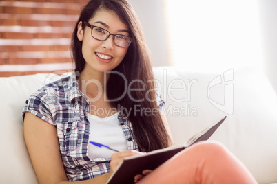 Asian woman on the couch writing