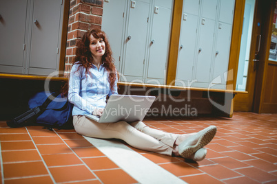 Mature student using laptop in hallway