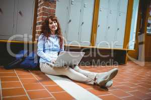 Mature student using laptop in hallway