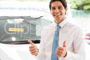 Smiling businessman standing while giving thumbs up