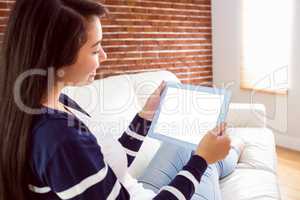 Asian woman on the couch using tablet