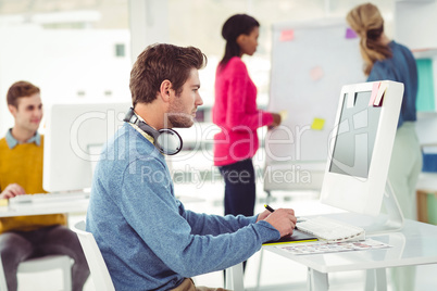 Graphic designer wearing headphones at desk