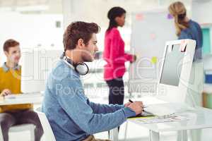 Graphic designer wearing headphones at desk