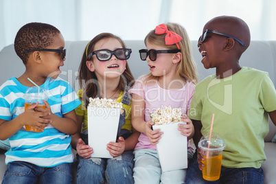 Happy kids enjoying popcorn and drinks while sitting