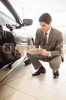 Focused businessman looking at the car body