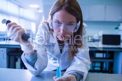 Scientist syringing chemical into test tube