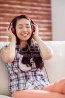 Asian woman on the couch listening to music