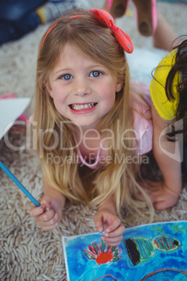 Smiling kid drawing pictures on paper