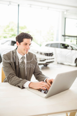 Smiling salesman behind his desk