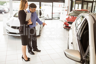 A man showing a car to the saleswoman A man showing a car to the saleswoman