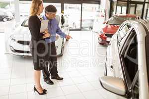 A man showing a car to the saleswoman