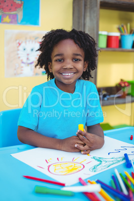 Happy kid drawing on his sheet