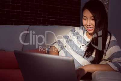 Asian woman using laptop at night