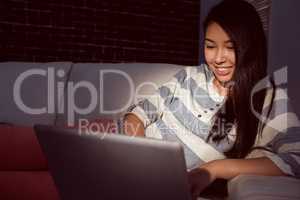 Asian woman using laptop at night