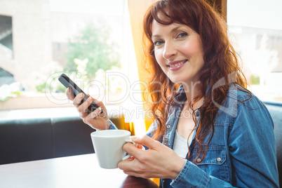 Mature student using phone in cafe