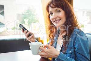 Mature student using phone in cafe