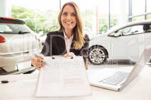 Smiling saleswoman holding a clipboard