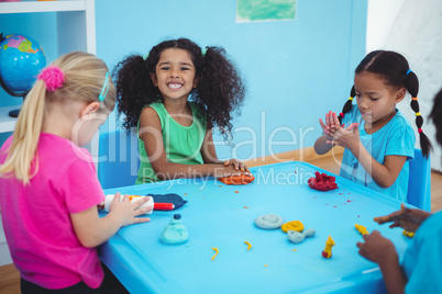 Smiling girls playing with modelling clay