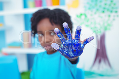 Happy kid enjoying painting with his hands