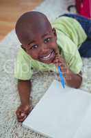 Smiling kid drawing pictures on paper