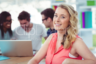 Smiling creative businesswoman working with co-workers