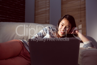 Asian woman using laptop at night