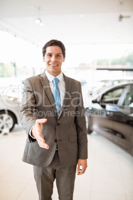 Smiling salesman ready to shake hand