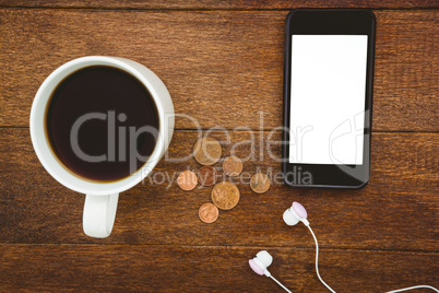 View of a black smartphone with a cup of coffee