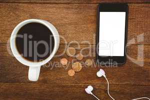 View of a black smartphone with a cup of coffee