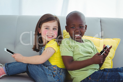 Smiling girl and boy using mobile phones