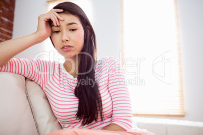 Upset asian woman on couch