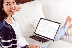 Asian woman on the couch using laptop